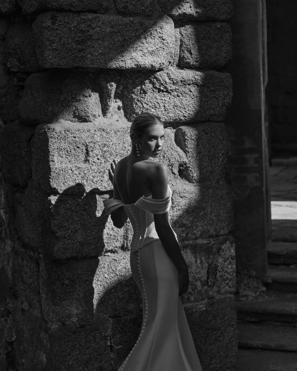 Robe de mariée PRAVIA Adriana Alier en mikado, coupe sirène, bustier corset et manches tombantes, vue de face.